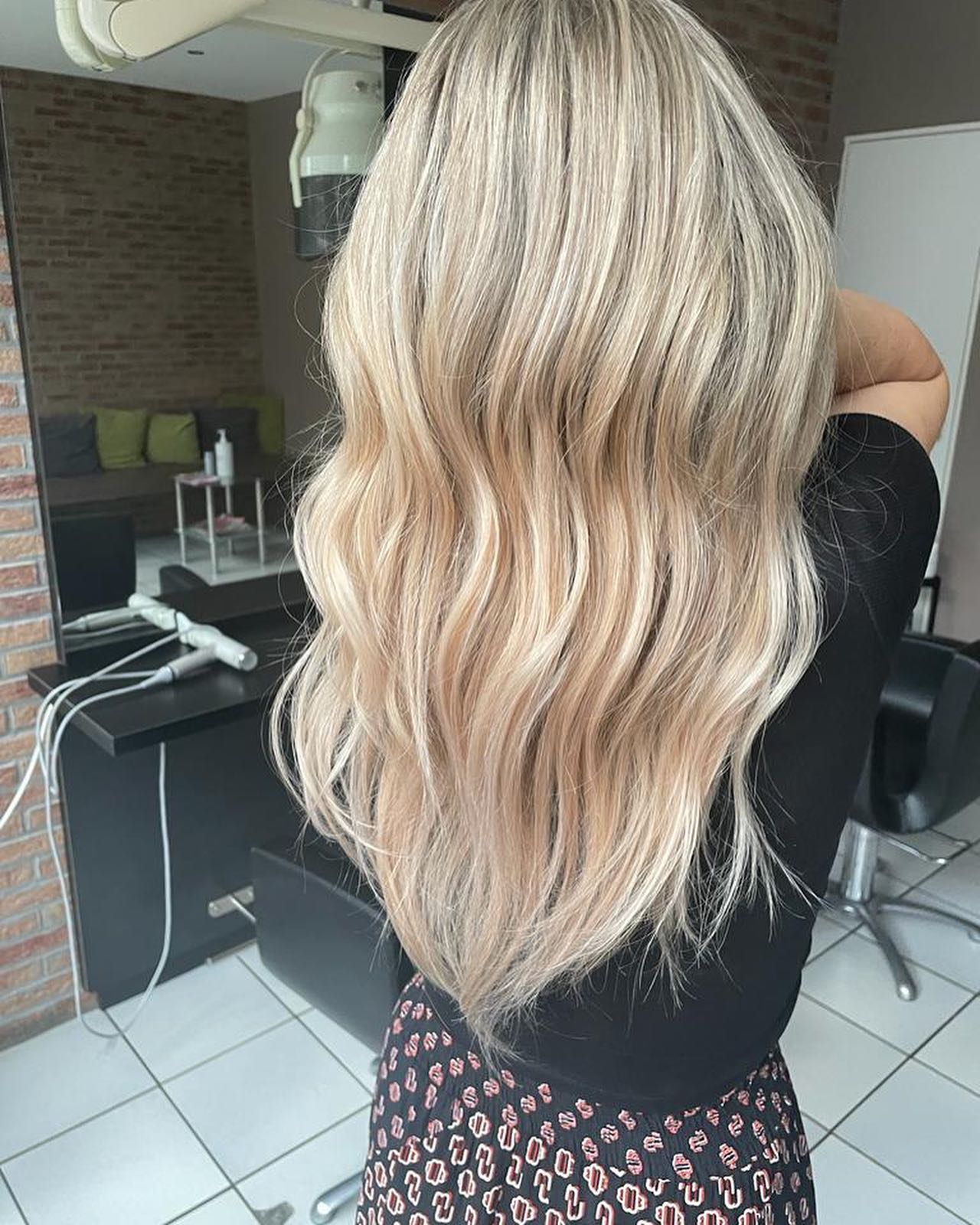 Lange blonde golven van achteren, in de salon